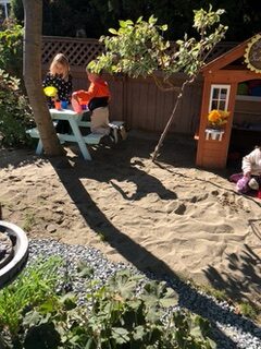 Coronation Montessori backyard sandbox with kids playing