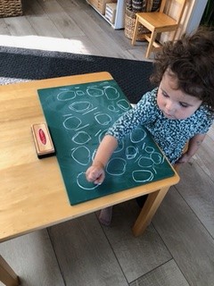 Coronation Montessori girl with chalkboard drawing circles in class