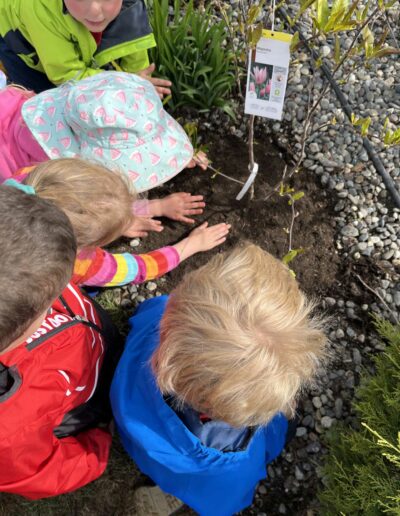Montessori children planting seeds outside